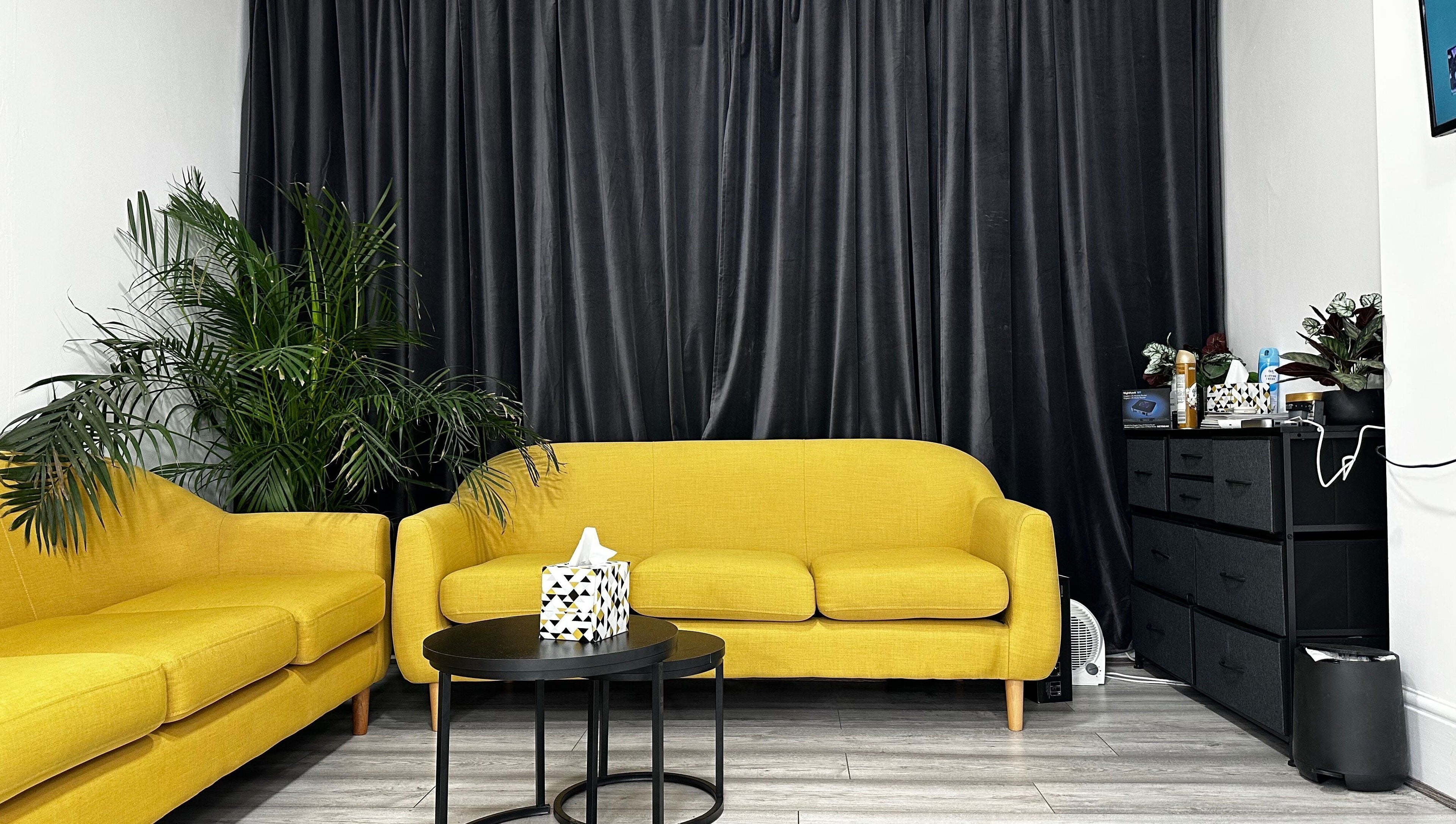Cozy yellow sofas at Aries Salon Academy, London, England, GB, offering a chic, welcoming atmosphere.