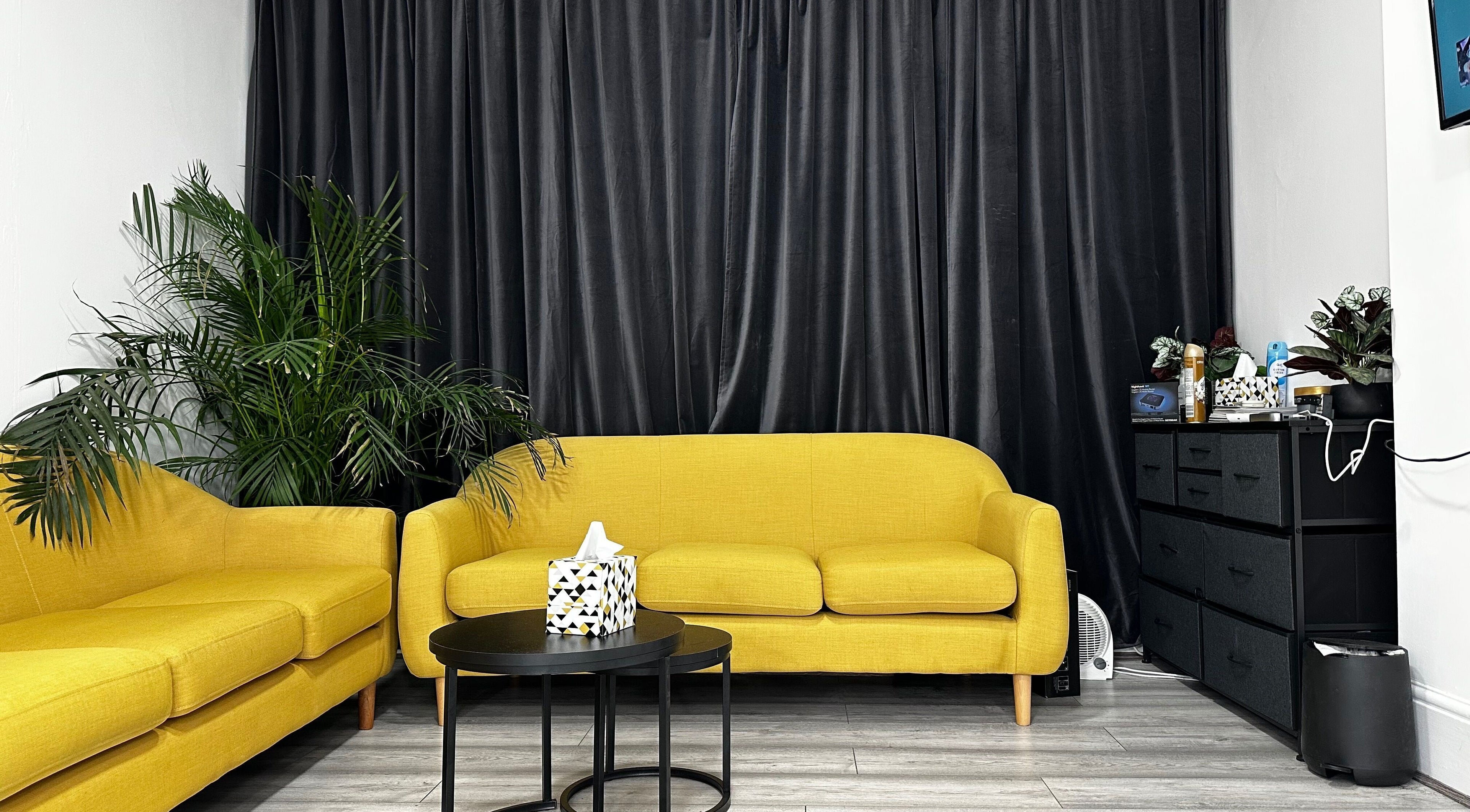 Cozy yellow sofas at Aries Salon Academy, London, England, GB, offering a chic, welcoming atmosphere.