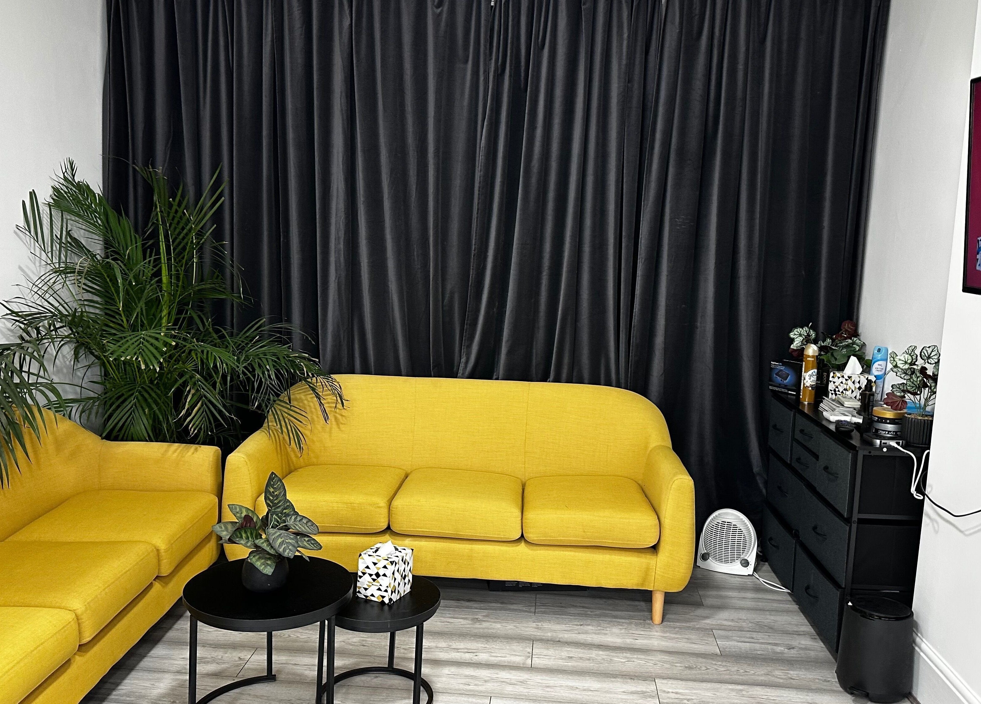 Modern lounge area with yellow sofas at Aries Salon Academy, London, England, GB. Stylish and relaxing venue space.