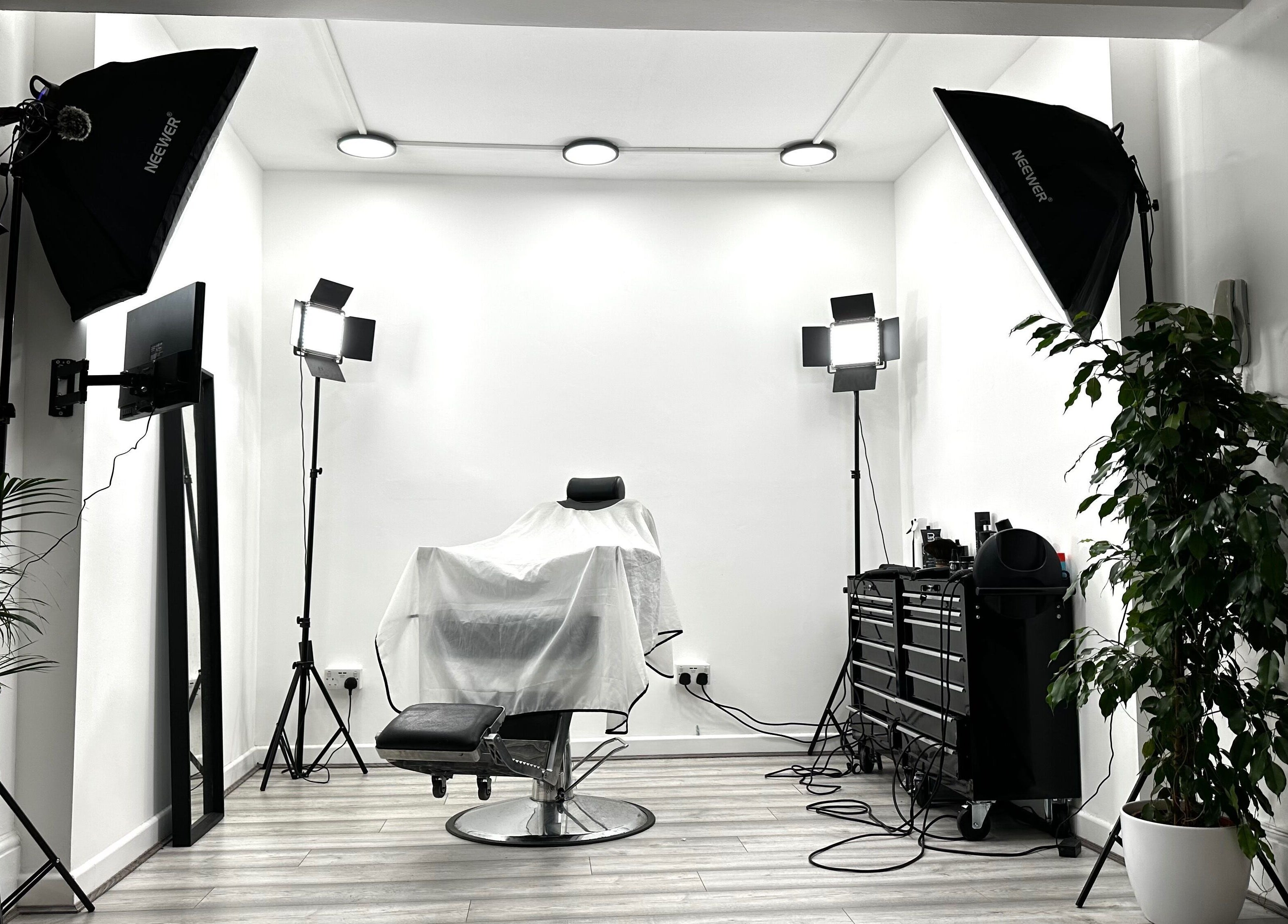 Professional styling chair at Aries Salon Academy in London, England, GB, surrounded by lighting and greenery.