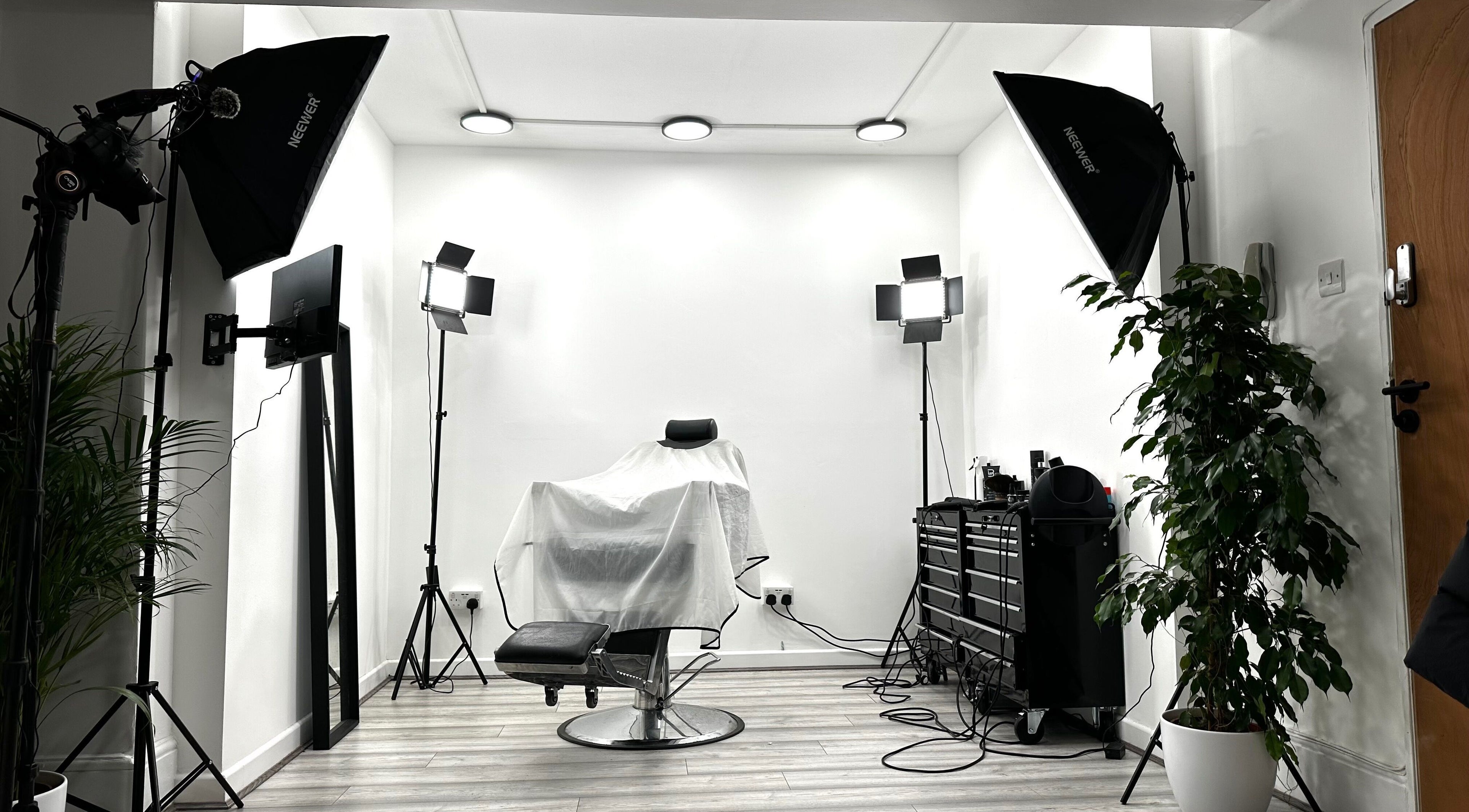 Professional styling chair at Aries Salon Academy in London, England, GB, surrounded by lighting and greenery.