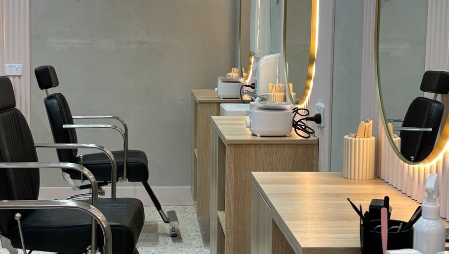 Sleek beauty stations at Lash & Brows Palace in Clarkson, Western Australia, AU with chairs and illuminated mirrors.