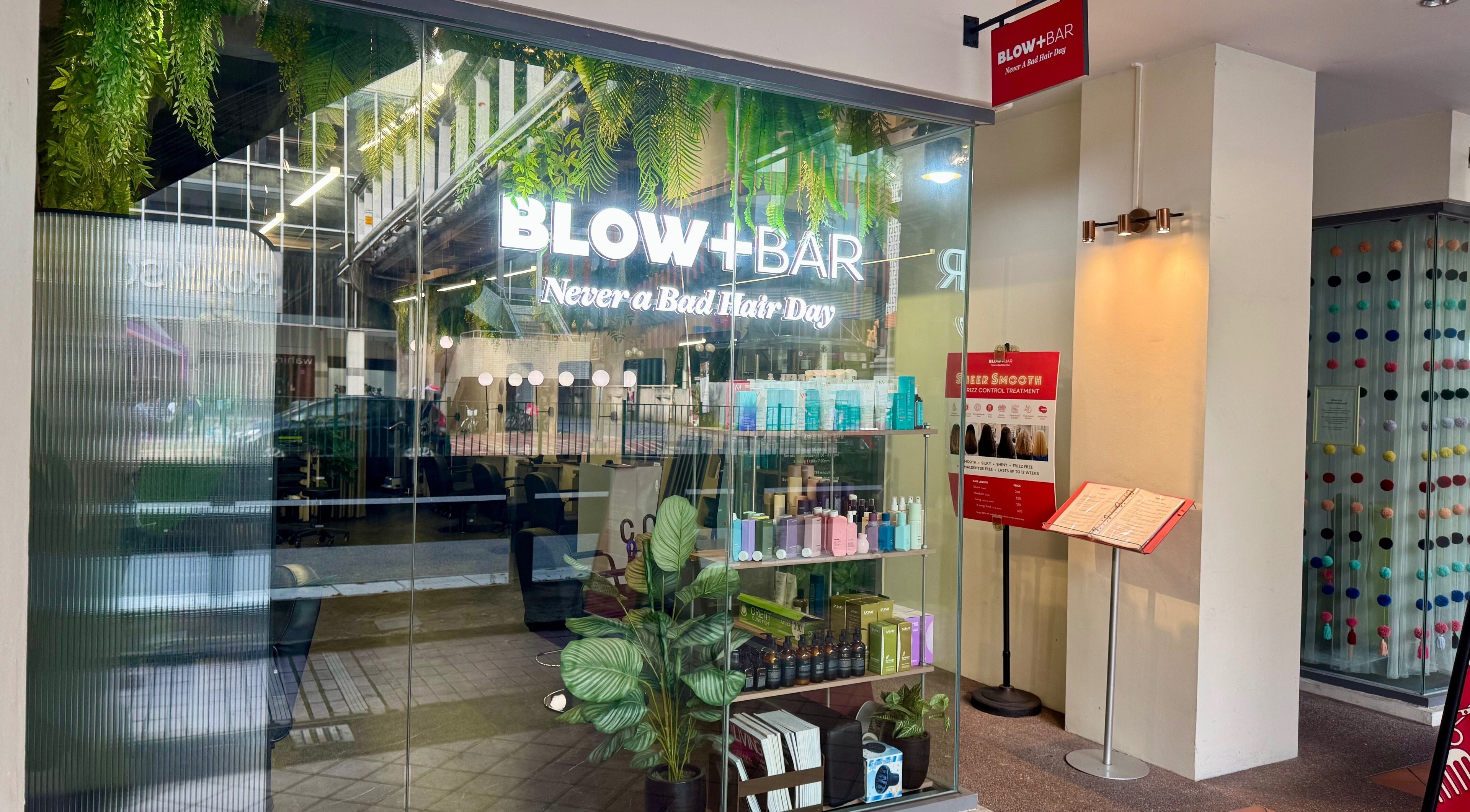 Chic Blow+Bar entrance in Singapore, featuring stylish decor and beauty products on display.