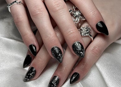 Elegant black nail art from Medusa’s Mantra, Greenbank, Queensland, AU. Silver rings add a stylish touch.