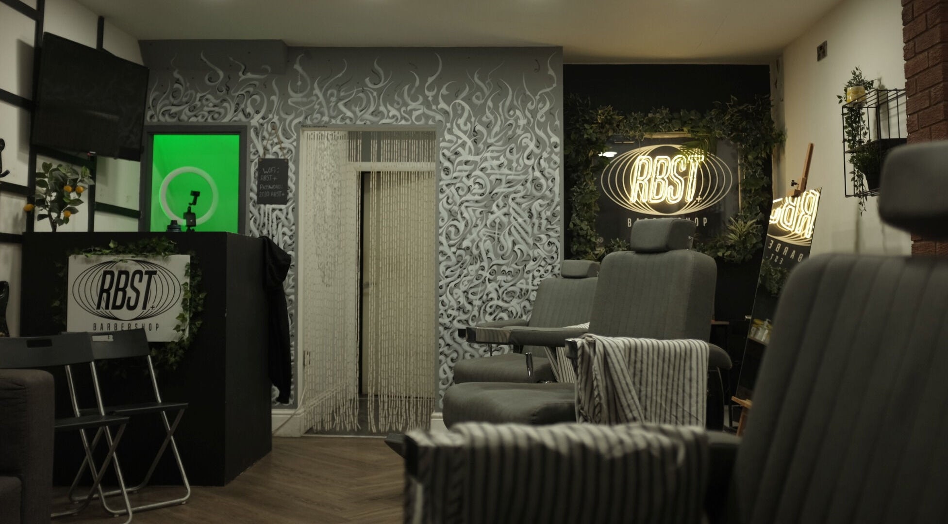 Stylish interior of RBST+ Barber Shop in Horwich, England, GB with modern chairs and artistic wall designs.