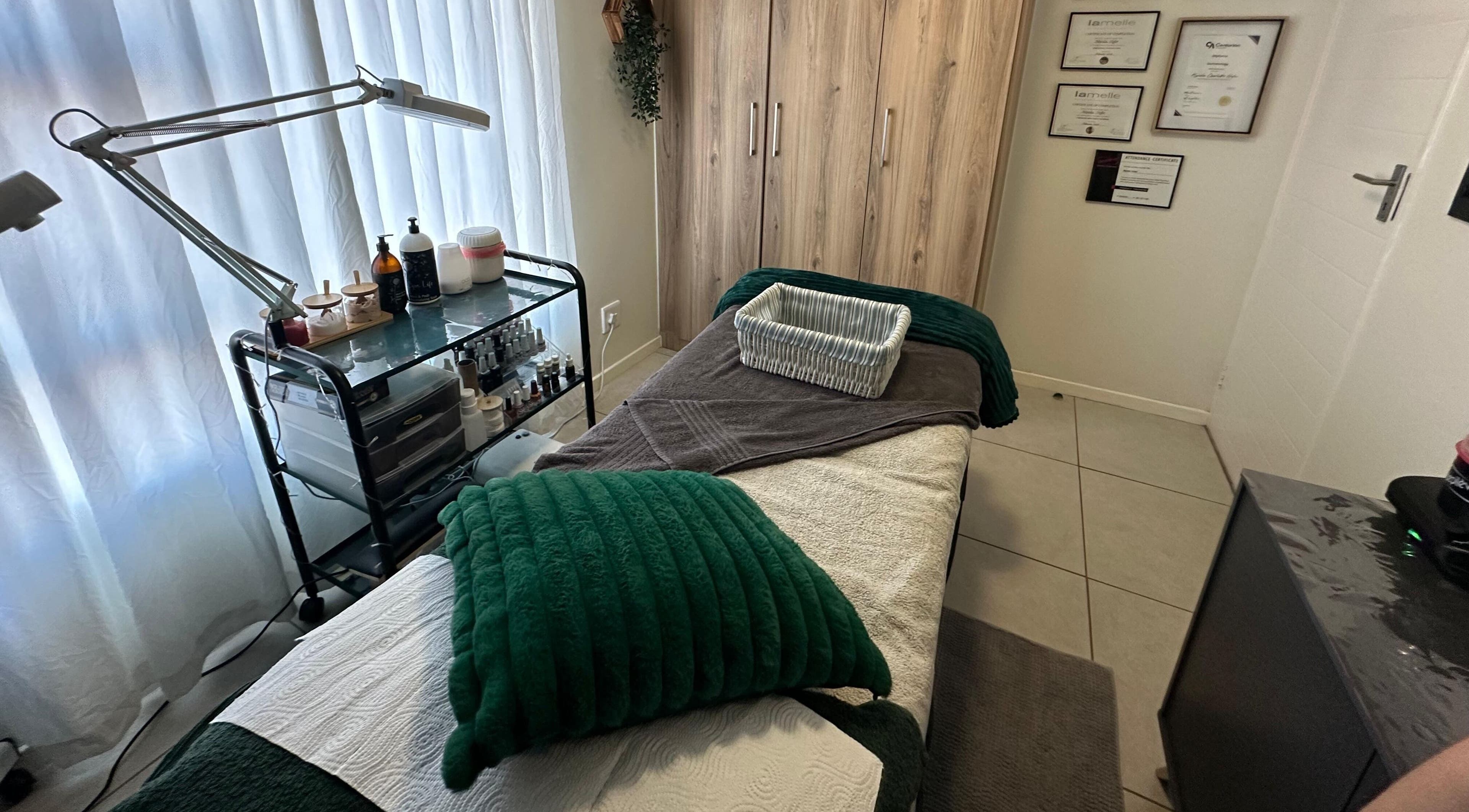 Cozy treatment room at XODERM in Centurion, Gauteng, ZA with a massage bed and skincare products.