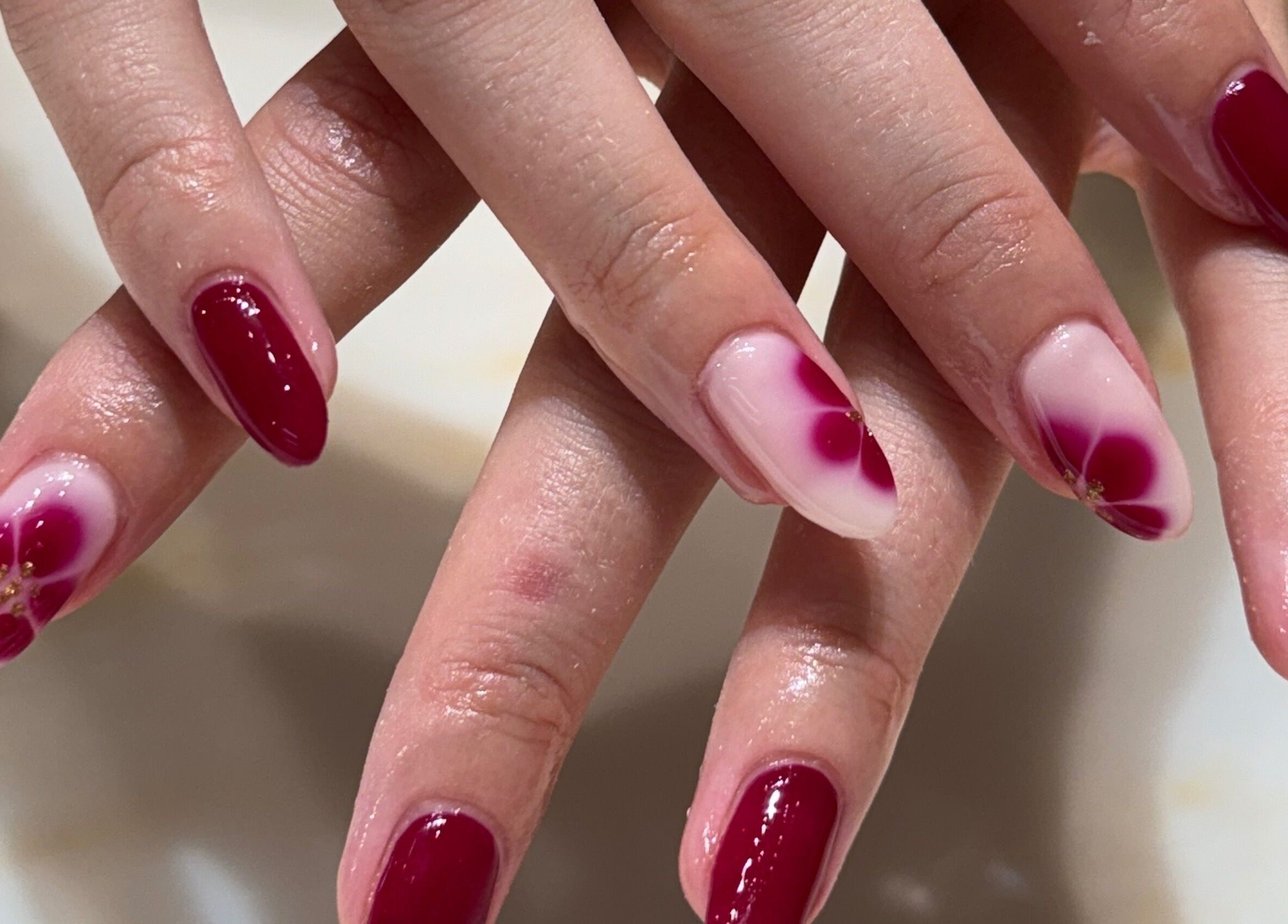 Elegant floral nail art at Solie Studios, Bristol, England, GB. Showcasing beautiful red and pink designs.