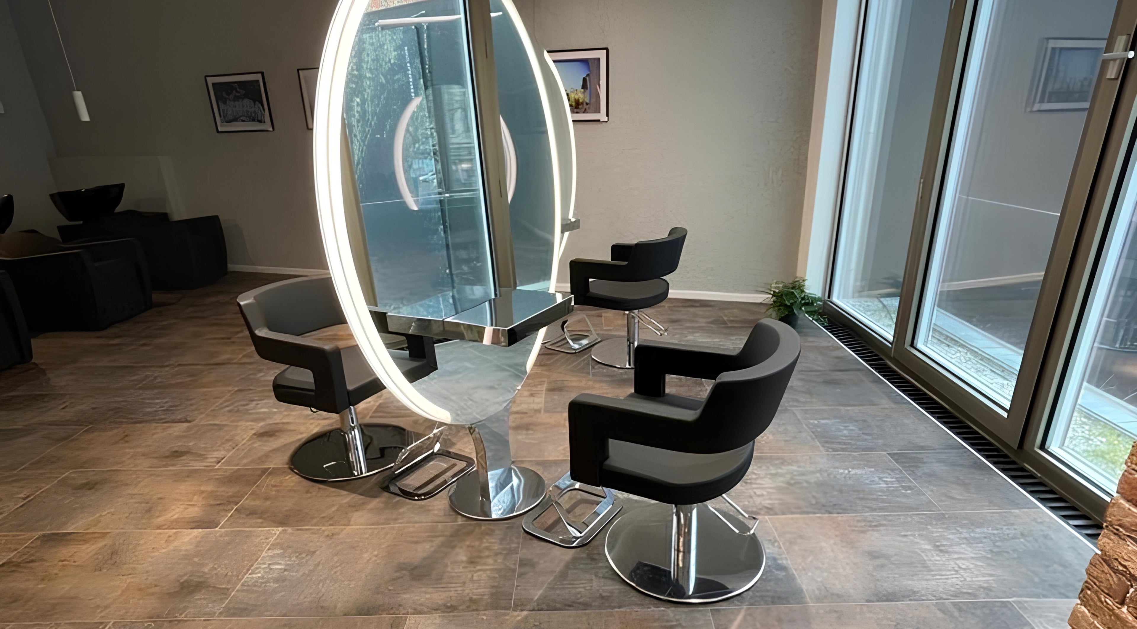 Moderne Einrichtung bei Pascal Conrad Hair in Berlin, Berlin, DE mit stilvollen Friseurstühlen und großem Spiegel.
