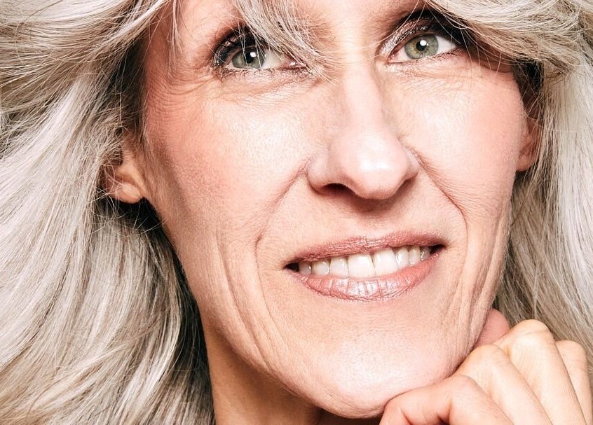 Stilvolle Frau mit grauem Haar lächelt bei Pascal Conrad Hair in Berlin, Berlin, DE.