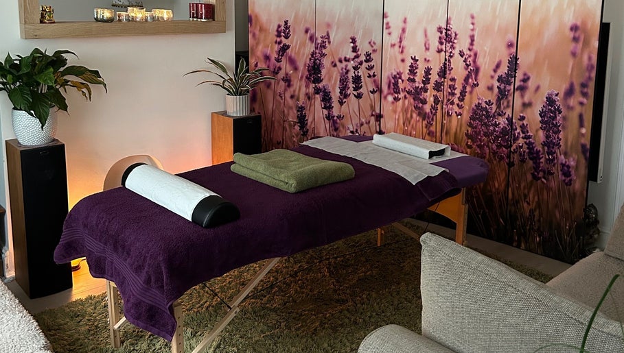 Massage table with purple decor at Mandala Massage in Berkhamsted, England, GB, featuring lavender artwork.