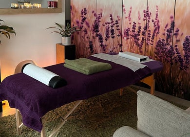 Massage table with purple decor at Mandala Massage in Berkhamsted, England, GB, featuring lavender artwork.