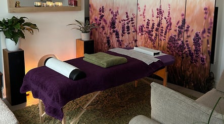 Massage table with purple decor at Mandala Massage in Berkhamsted, England, GB, featuring lavender artwork.