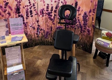 Lavender-themed massage setup at Mandala Massage, Berkhamsted, England, GB, featuring a chair and promotional materials.