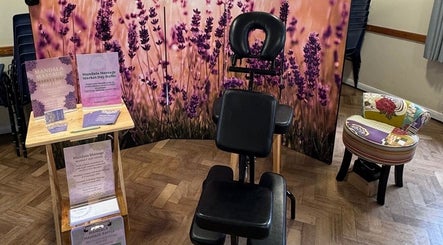 Lavender-themed massage setup at Mandala Massage, Berkhamsted, England, GB, featuring a chair and promotional materials.
