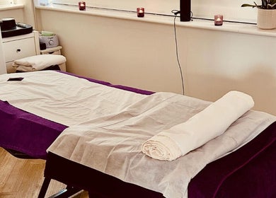 Serene massage table setup at Mandala Massage in Berkhamsted, England, GB, featuring calming candles and soft lighting.