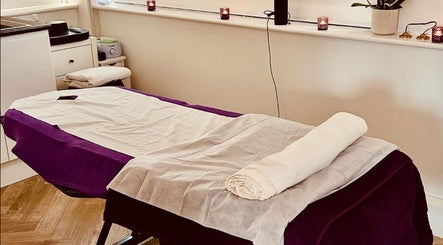 Serene massage table setup at Mandala Massage in Berkhamsted, England, GB, featuring calming candles and soft lighting.