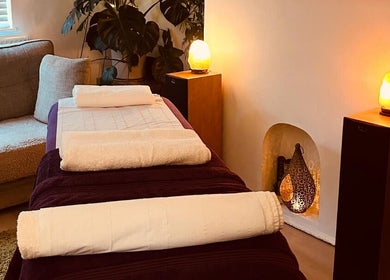 Relaxing massage bed setup at Mandala Massage, Berkhamsted, England, GB, with soft lighting and plush towels.