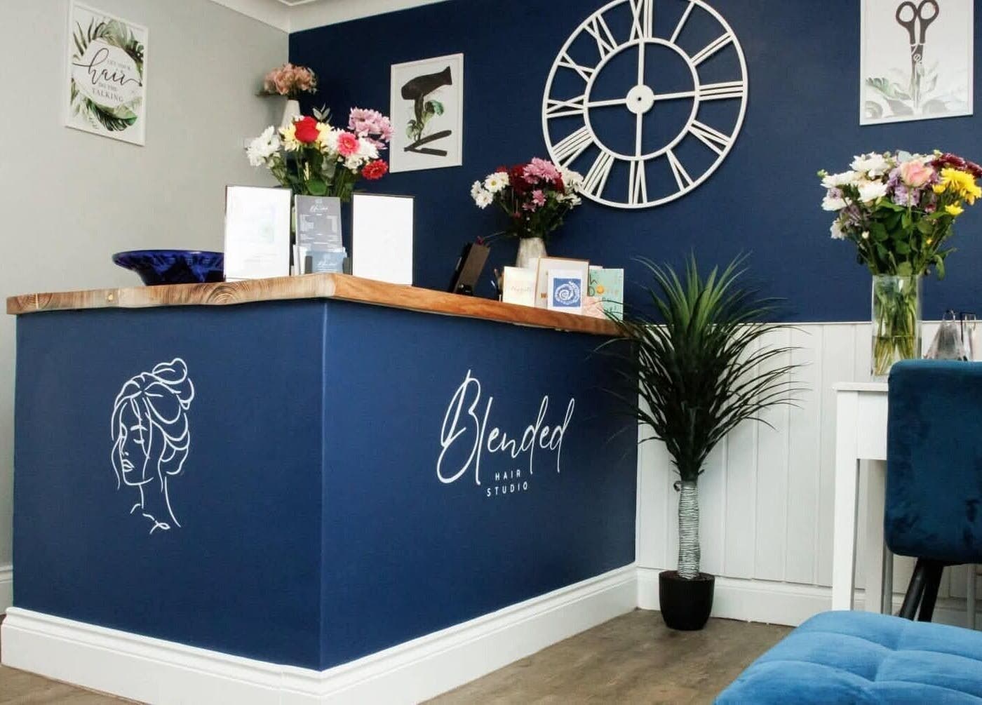 Welcome desk at Blended Hair Studio in Dereham, England, GB, showcasing chic décor and vibrant flowers.