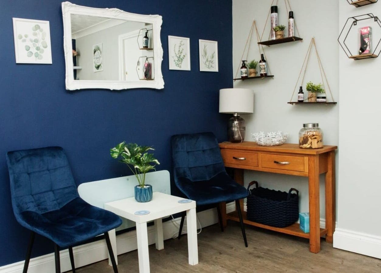 Stylish waiting area of Blended Hair Studio, Dereham, England, GB with blue chairs and wooden decor.