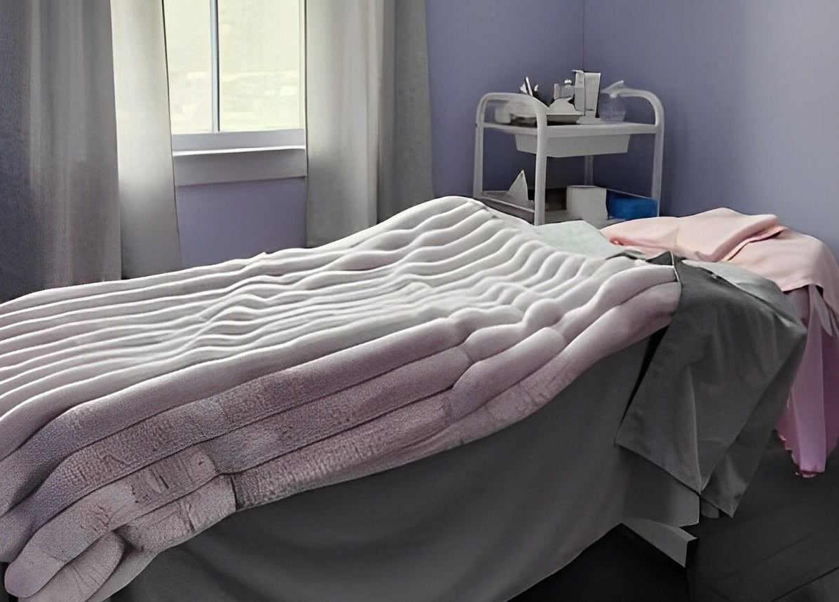Cozy massage room at Times Aesthetic in Markham, Ontario, CA with plush blankets and soothing decor.