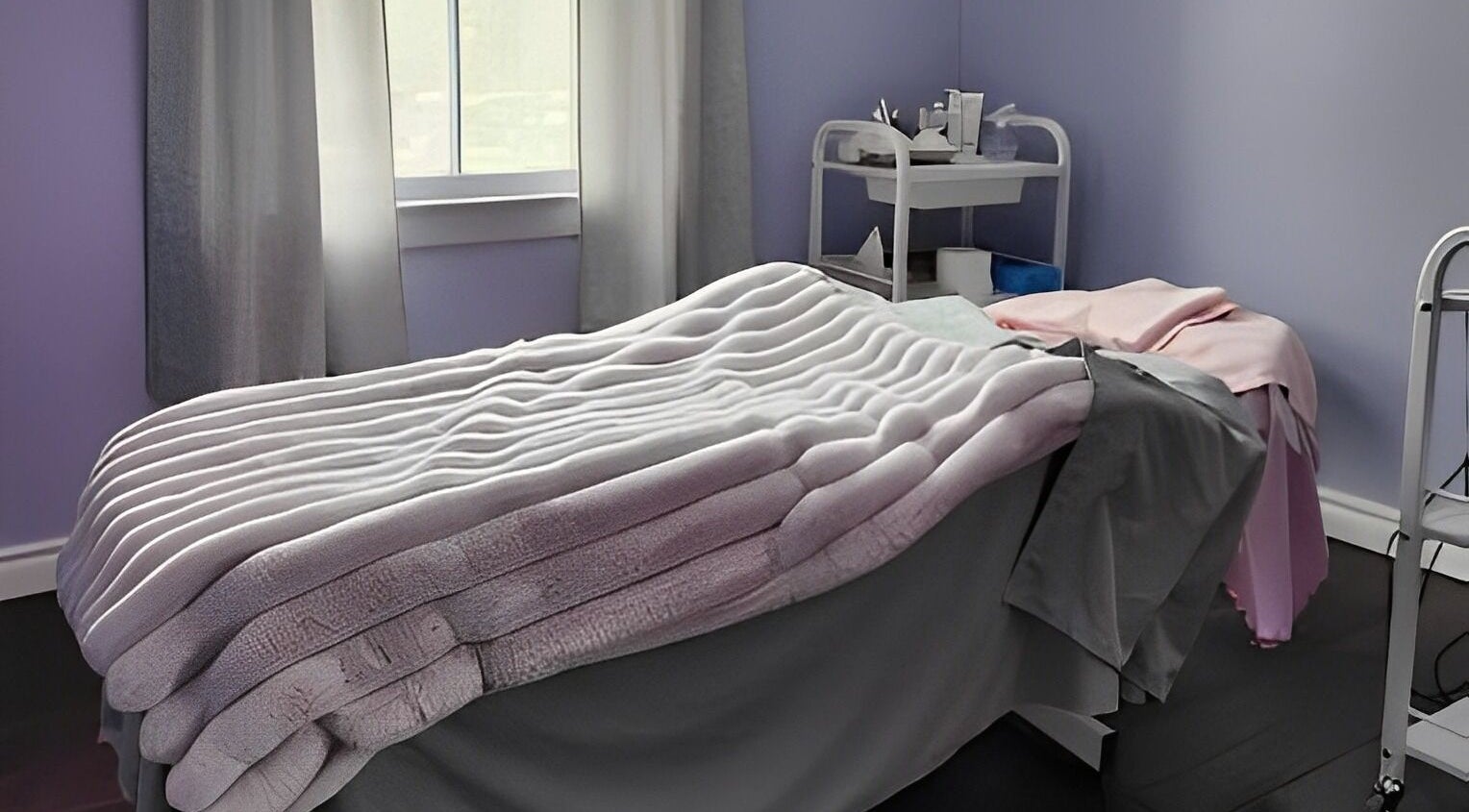 Cozy massage room at Times Aesthetic in Markham, Ontario, CA with plush blankets and soothing decor.