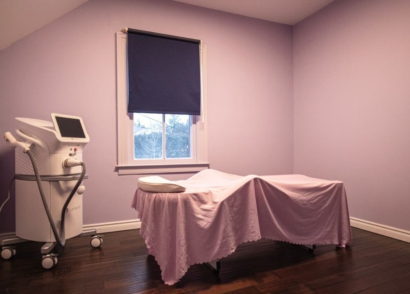 Calming treatment room at Times Aesthetic, Markham, Ontario, CA with lavender walls and advanced equipment.