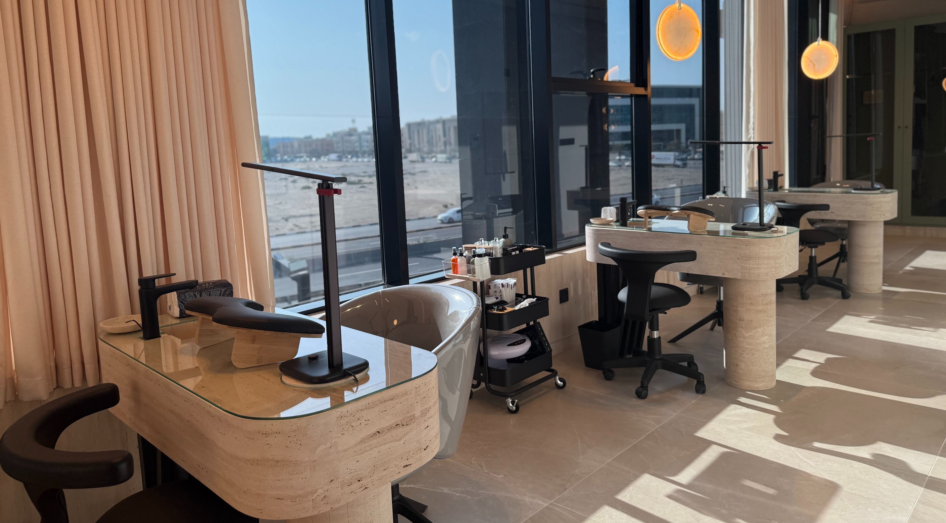Modern manicure stations at Fayya Beauty Salon & Spa in Al Khobar, Eastern Province, SA with large windows.