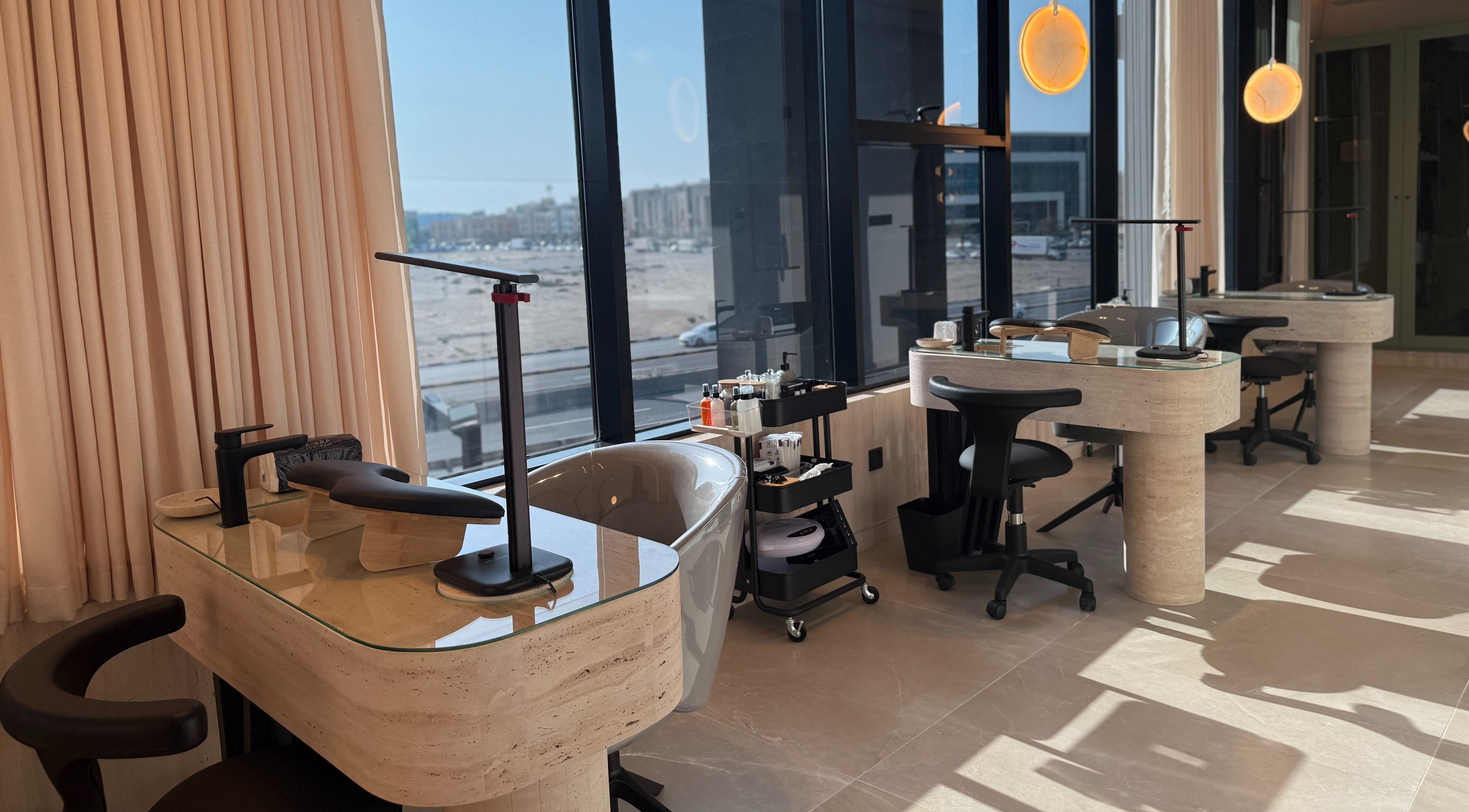 Modern manicure stations at Fayya Beauty Salon & Spa in Al Khobar, Eastern Province, SA with large windows.