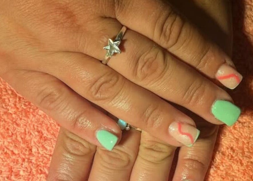 Stylish nail art with green and red accents at M & M Nails, Frome, England, GB.