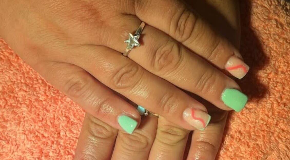 Stylish nail art with green and red accents at M & M Nails, Frome, England, GB.