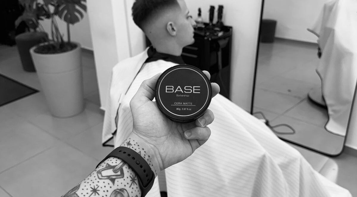 Produto Base Barbershop em corte moderno, Rio Grande Do Sul, BR nas mãos de um tatuado.