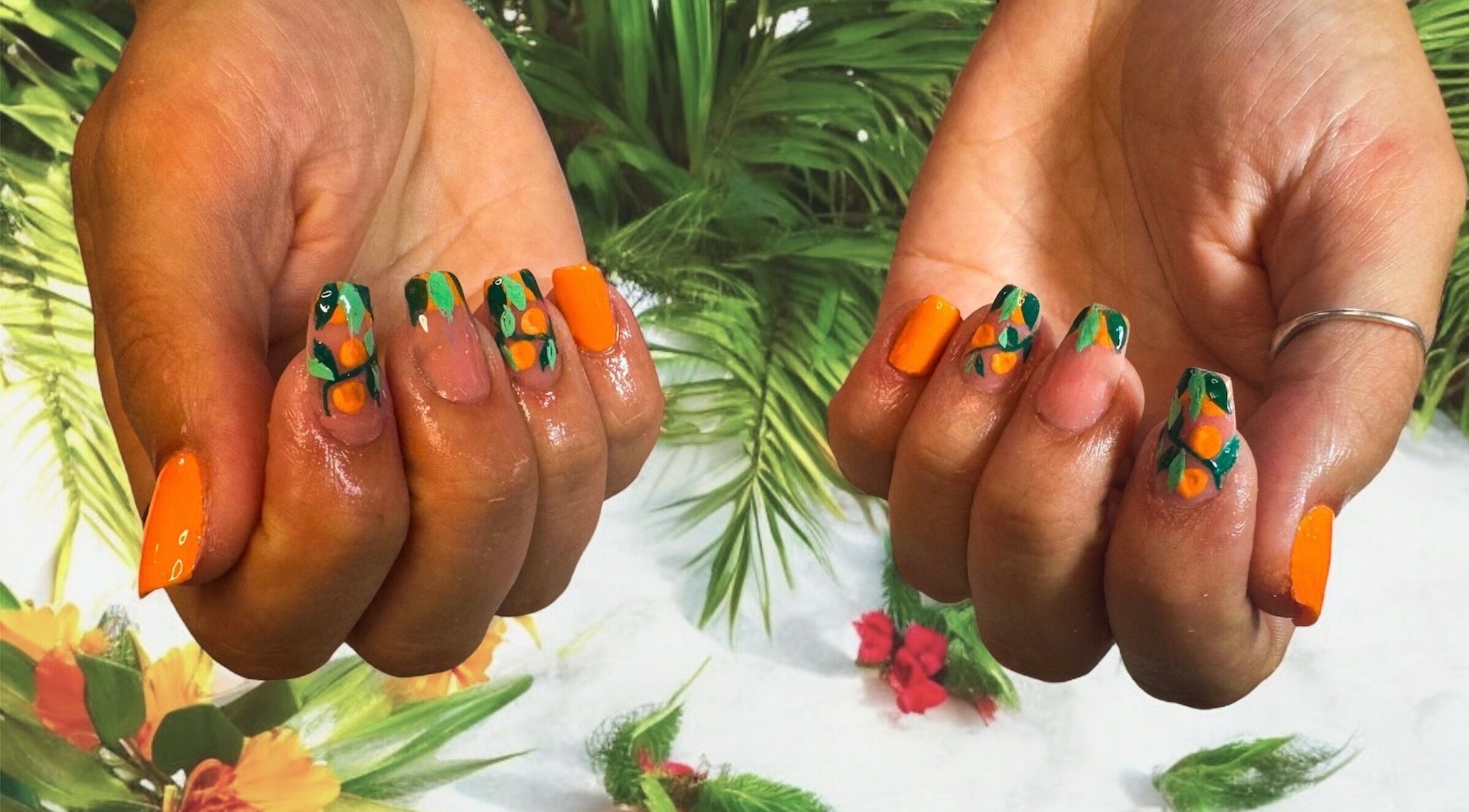 Colorful tropical nail art at Jazz Hands in Ripon, England, GB, showcasing vibrant orange and green designs.