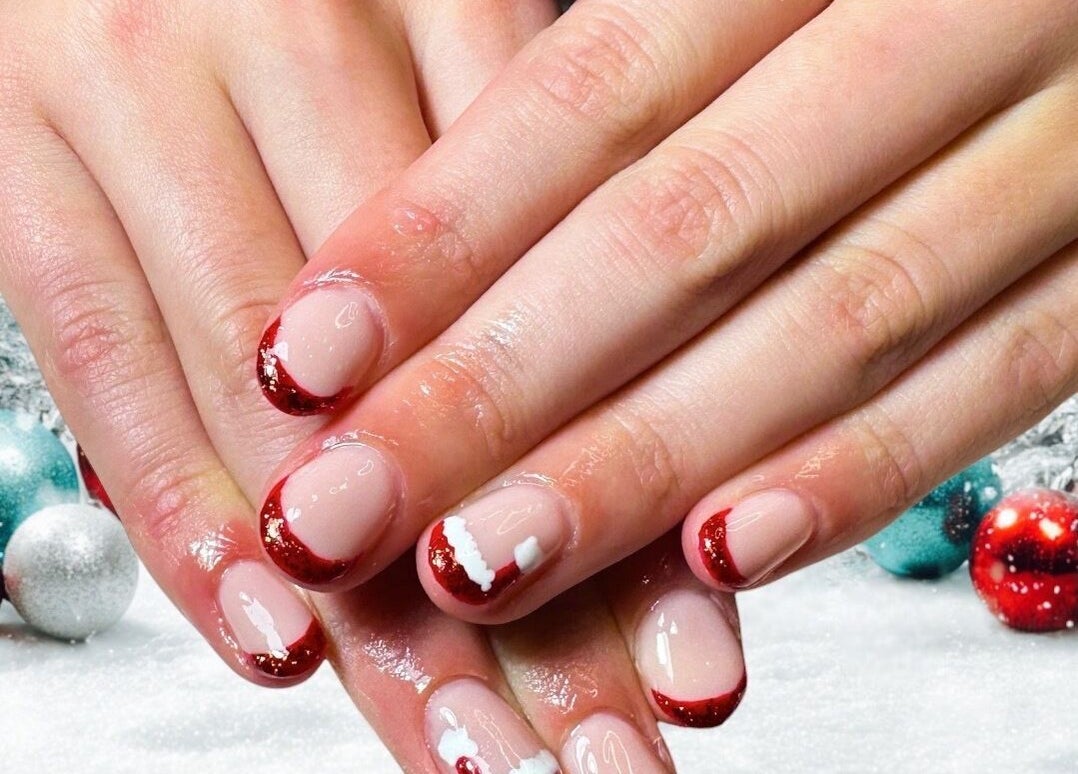 Festive nail art at Jazz Hands in Ripon, England, GB. Red and white manicure on a hand.