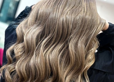Beautiful wavy blonde hairstyle created at Hair By Aimee in Birmingham, England, GB. Shiny waves in natural light.