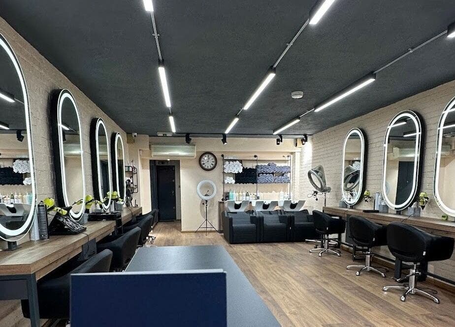 Interior of Omis Hair West Hampstead, London, England, GB featuring modern styling stations and mirrors.