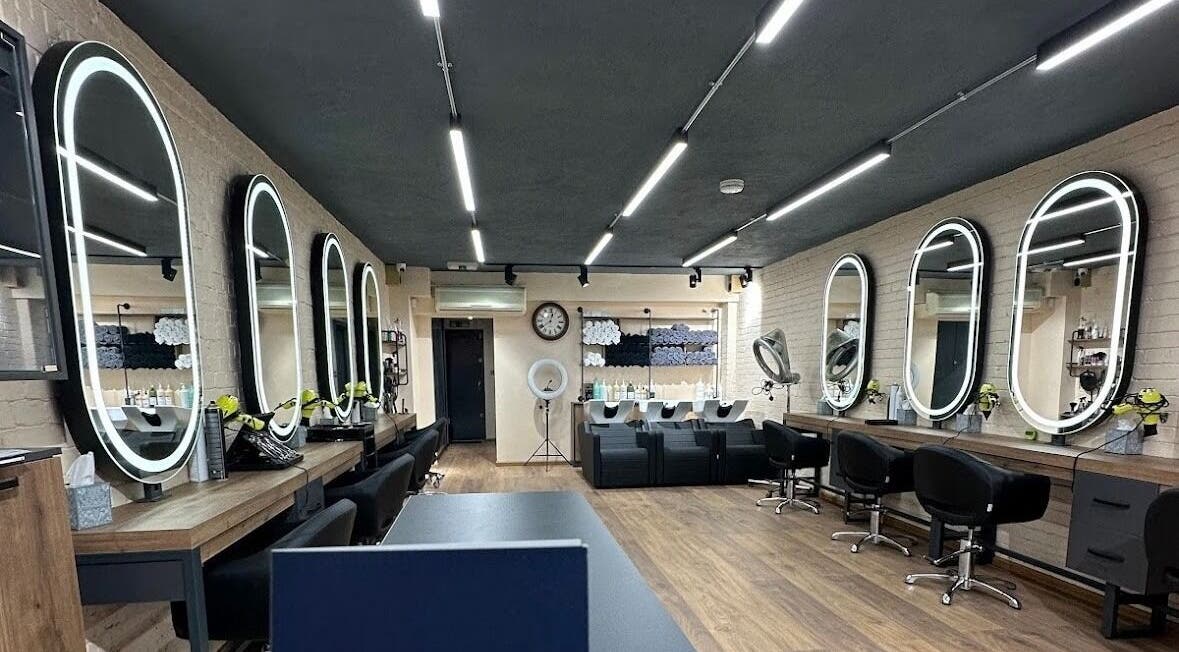 Interior of Omis Hair West Hampstead, London, England, GB featuring modern styling stations and mirrors.