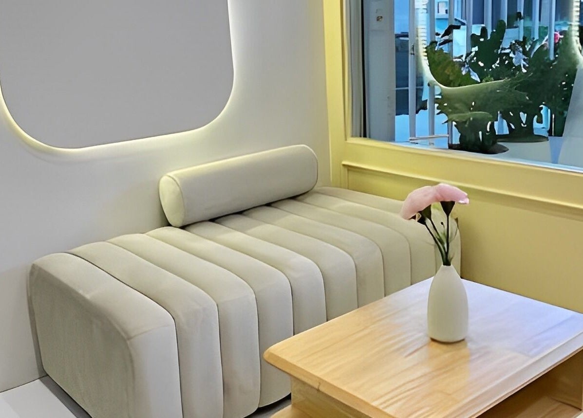 Modern lounge area at Ing Aesthetic in Krung Thep Maha Nakhon, featuring a cozy sofa and elegant decor.