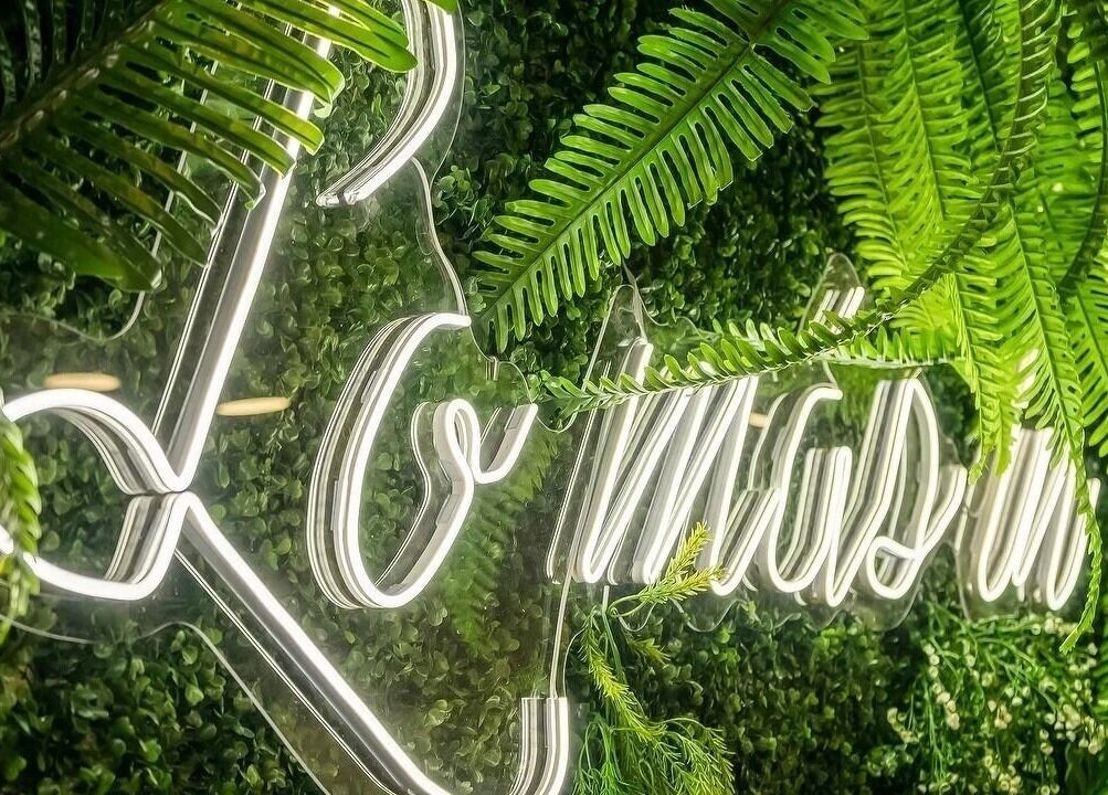 Neón rodeado de plantas verdes en Lo Más In - El Bercial, Getafe, Comunidad De Madrid, ES.