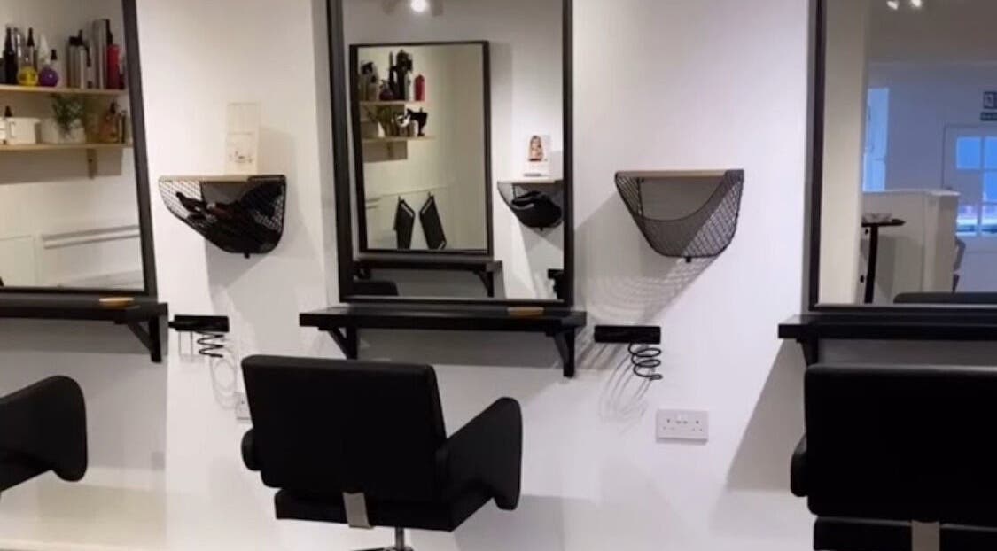 Modern salon interior at Hidden Beauty Exeter, featuring sleek styling chairs and mirrors in Exeter, England, GB.