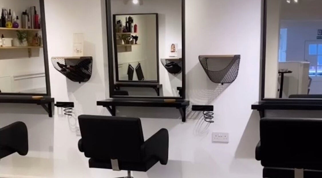 Modern salon interior at Hidden Beauty Exeter, featuring sleek styling chairs and mirrors in Exeter, England, GB.