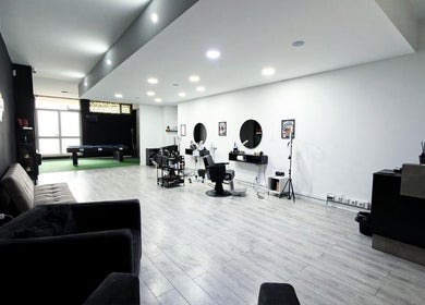 Interior moderno da Barbearia Maia em Braga, Braga, PT, com poltronas confortáveis e espelhos circulares.