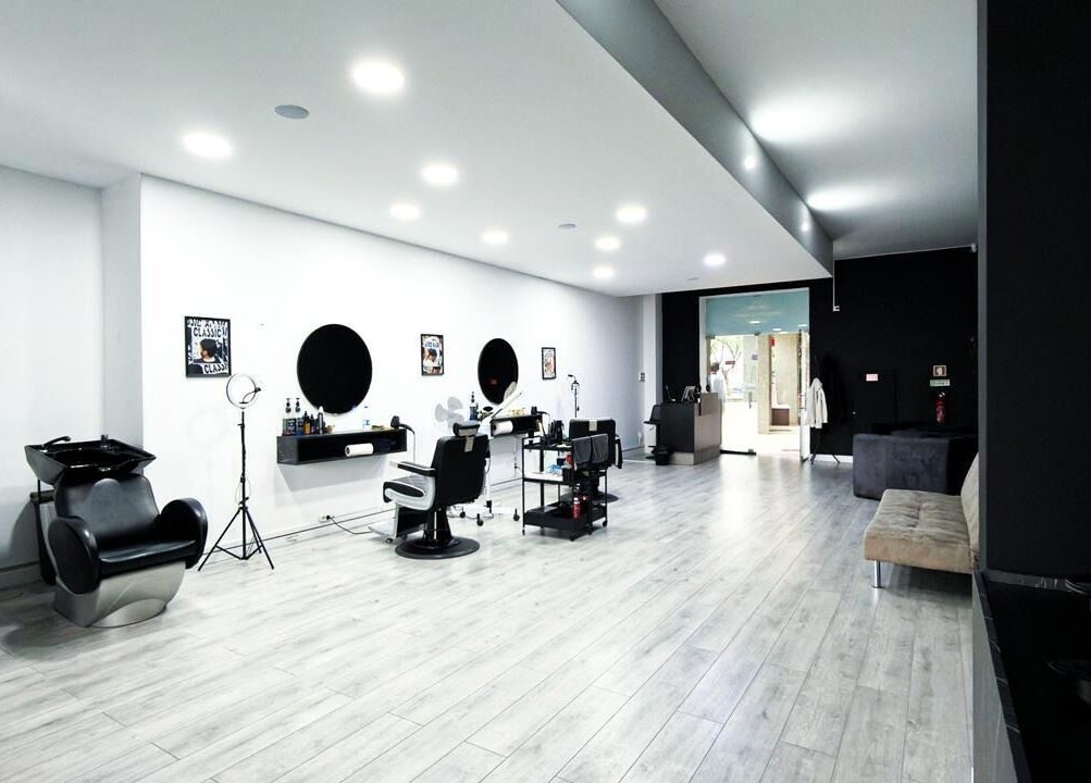 Interior moderno de Barbearia Maia em Braga, Braga, PT, com cadeiras e espelhos elegantes.