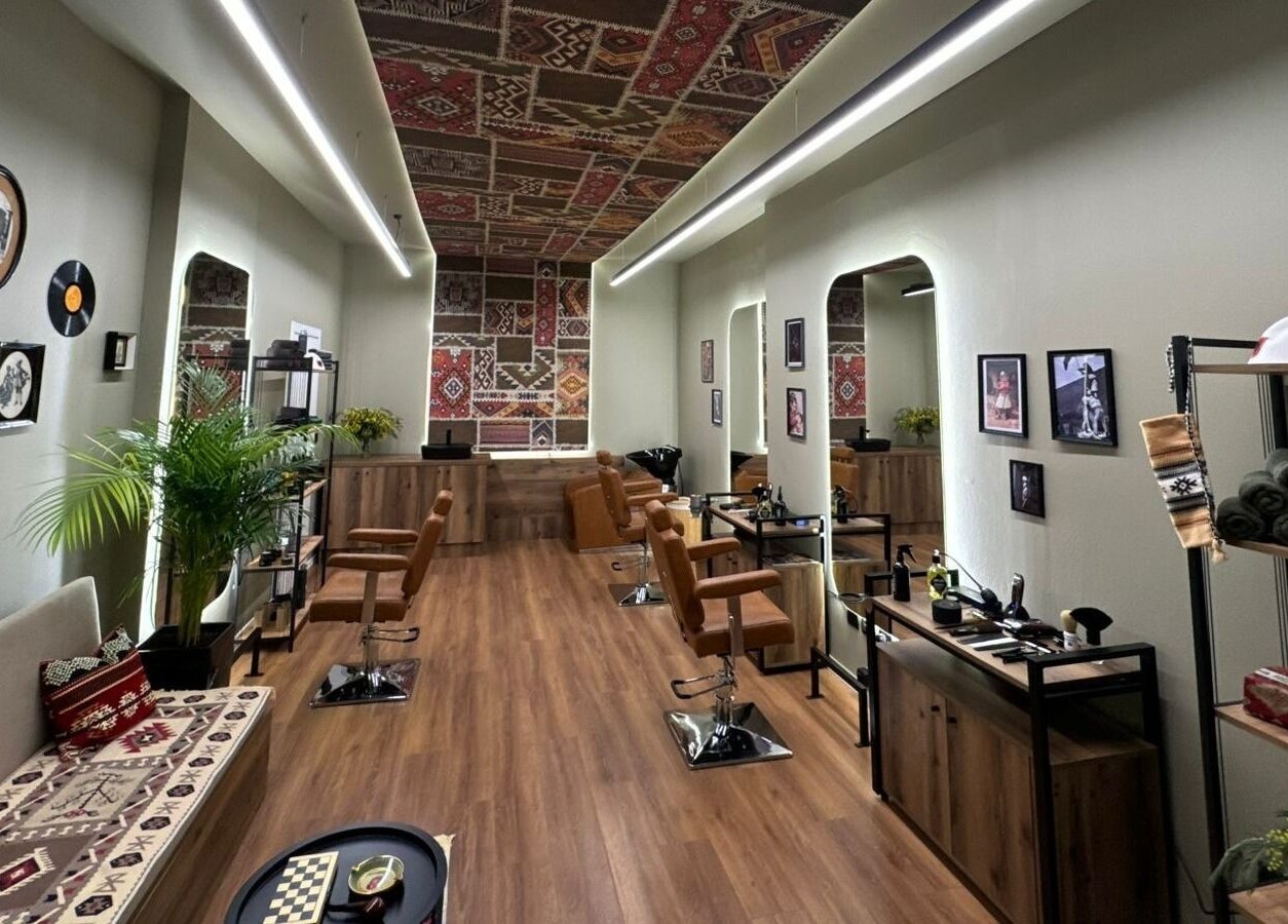 Cozy interior of Oda Barber Shop in Tiranë, Qarku I Tiranës, AL featuring elegant decor and barber chairs.