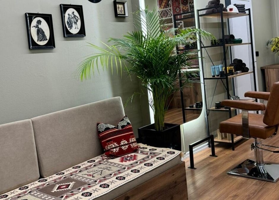 Interior of Oda Barber Shop in Tiranë, featuring a stylish chair, vibrant plants, and modern decor.