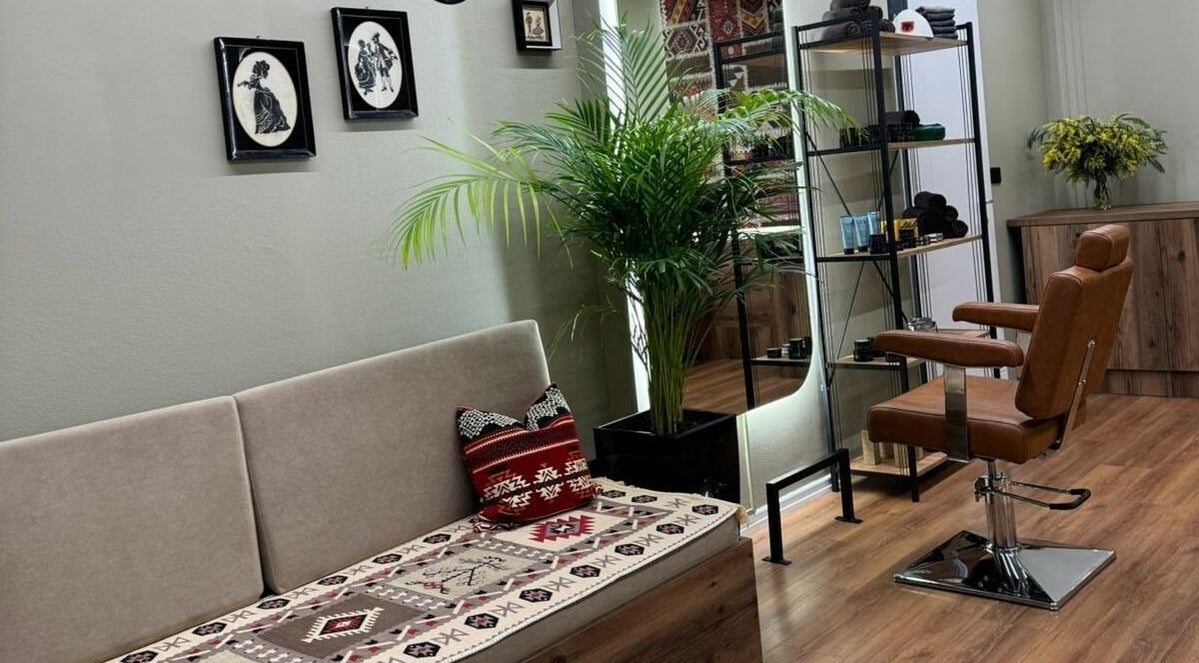 Interior of Oda Barber Shop in Tiranë, featuring a stylish chair, vibrant plants, and modern decor.