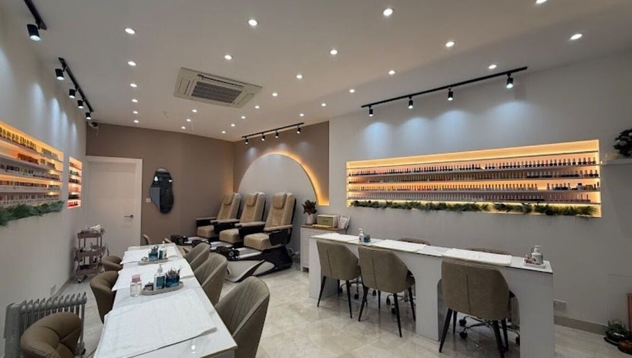 Modern interior of Exquisique Nails & Beauty salon in Epsom, England, GB with elegant nail stations and cozy chairs.
