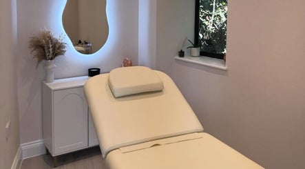 Relaxing treatment room at Exquisique Nails & Beauty, Epsom, England, GB with ambient lighting and a plush bed.