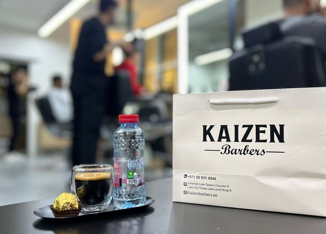 Relaxing setting at Kaizen Barbershop, Dubai, Dubai, AE with drink and chocolate on a table.