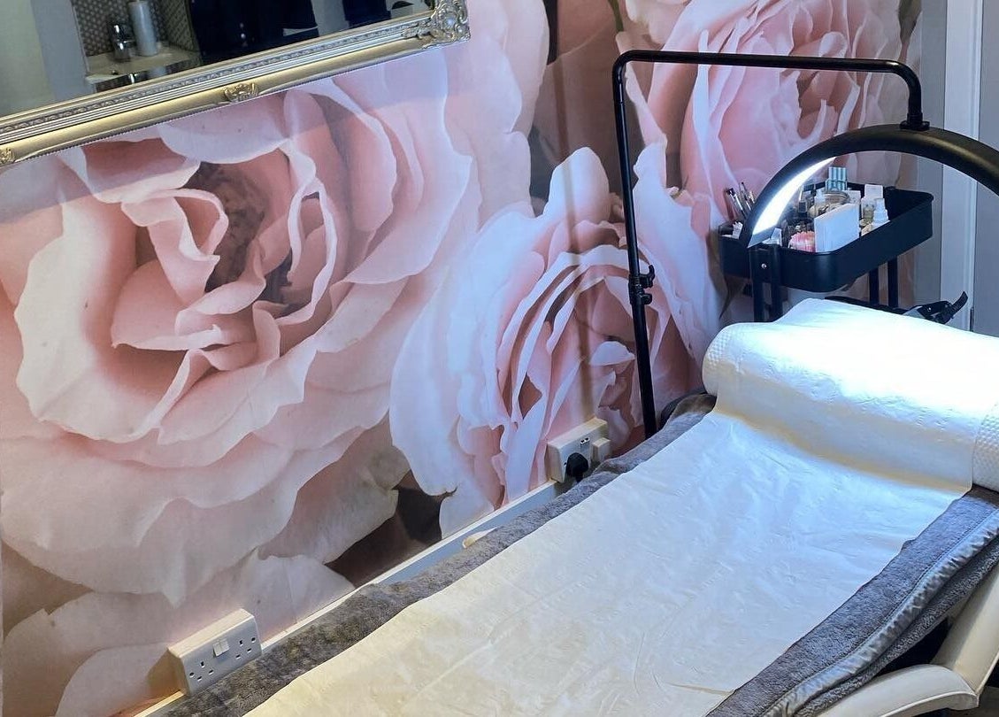 Elegant spa bed at Perfect You in Teddington, England, GB with a soft pink rose wall mural.