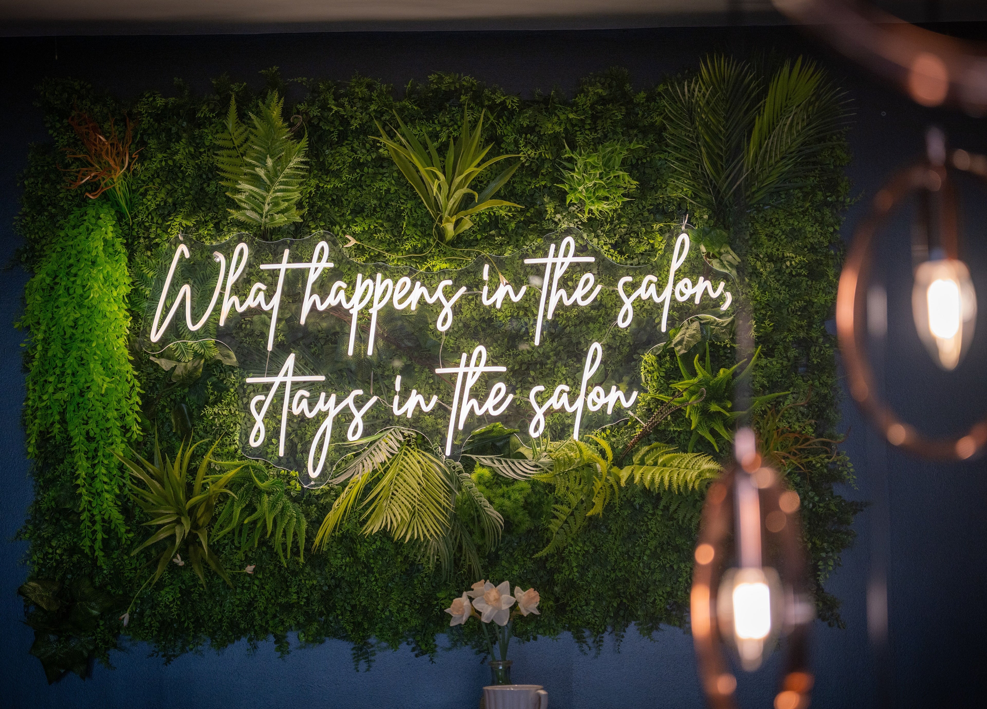 Lush greenery wall with neon sign at Perfect You in Teddington, England, GB, creating a calming ambiance.